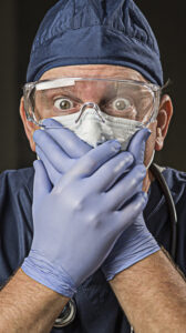 Stunned Male Doctor or Nurse with Protective Wear and Stethoscope.