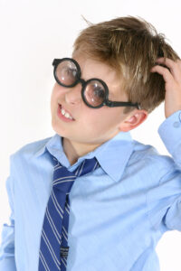 School student in comical spectacles scratching head